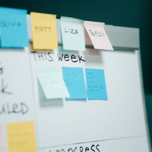 Close-up of a whiteboard with colorful sticky notes for task organization and planning.