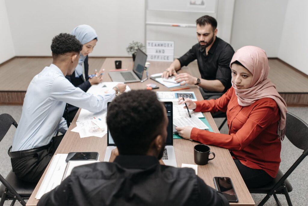 A diverse team of coworkers engaged in a productive meeting at a modern office conference table.
