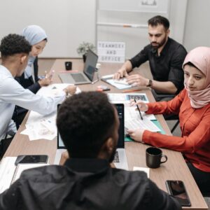 A diverse team of coworkers engaged in a productive meeting at a modern office conference table.