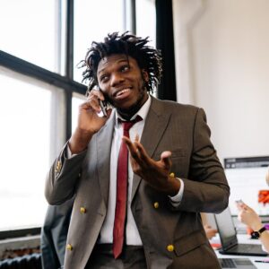 Professional businessman smiling while talking on the phone in an office setting.